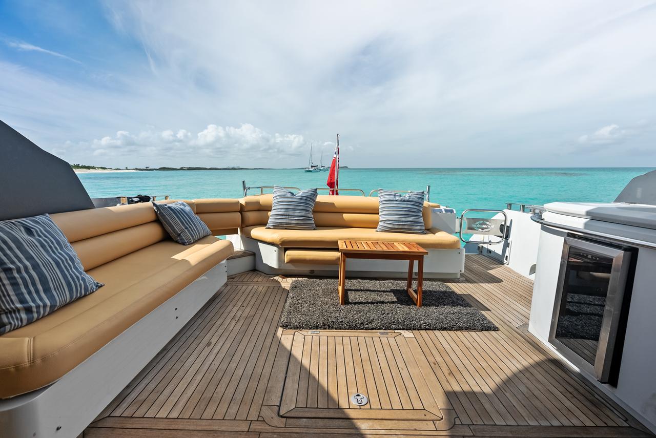 An aft-deck lounge with sofas and a coffee table aboard a motor yacht