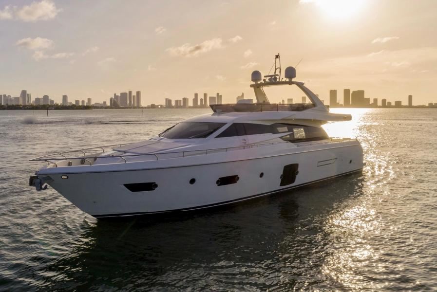 A flybridge yacht in Biscayne Bay at sunset with the Miami skyline behind