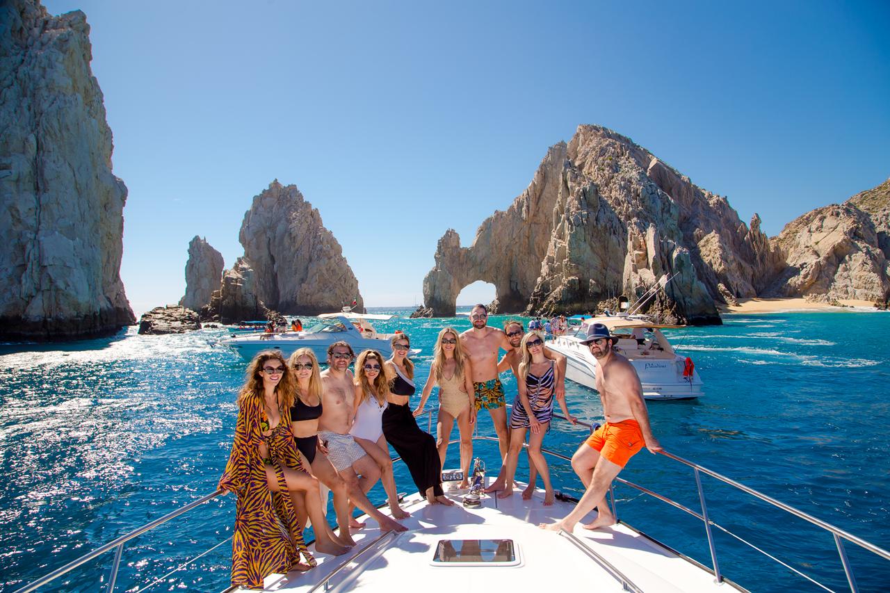 A group celebrating aboard a private yacht in front of El Arco in Cabo San Lucas