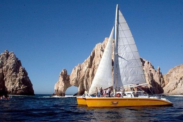 A sailing catamaran passing El Arco in Cabo San Lucas