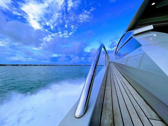 The polished side deck of a sport yacht under way